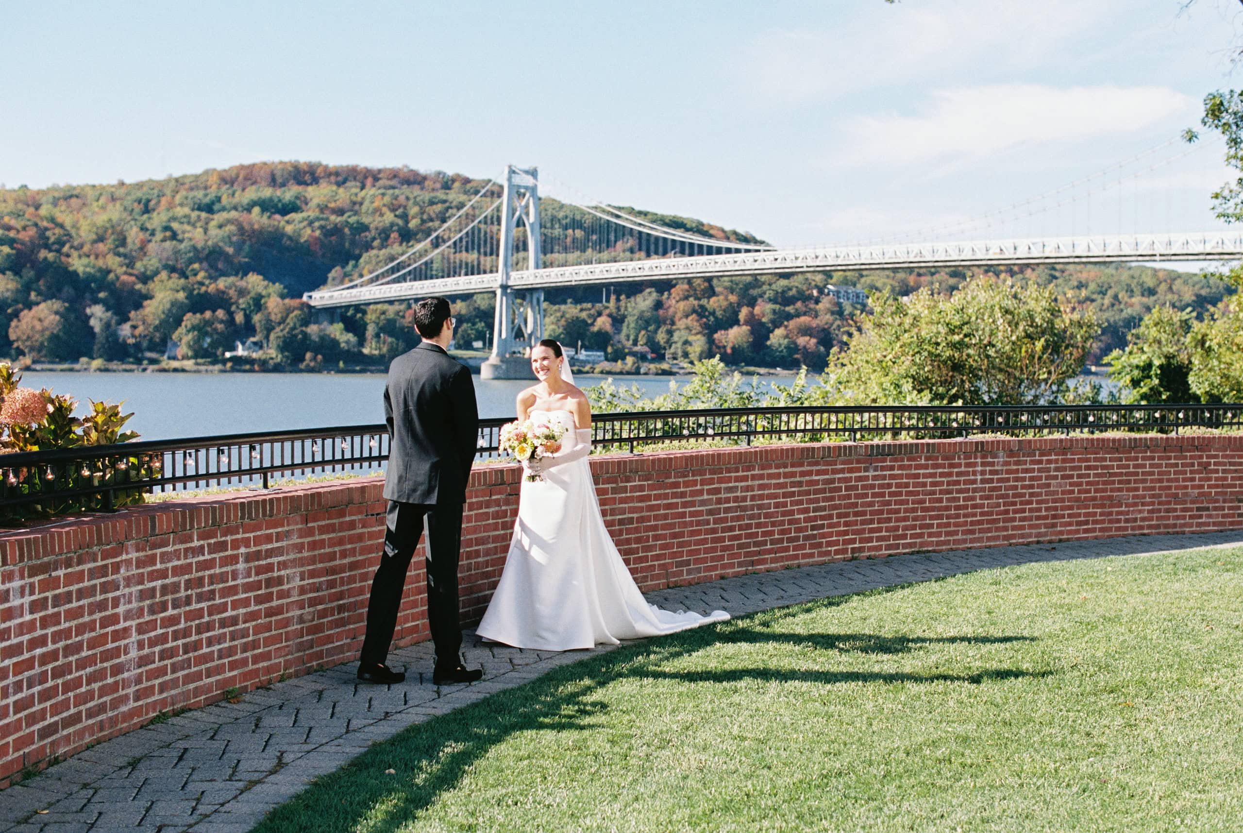 Elizabeth and Matt at The Grandview brick terrace wall with Mid-Hudson Bridge and fall foliage — Hudson Valley wedding photography