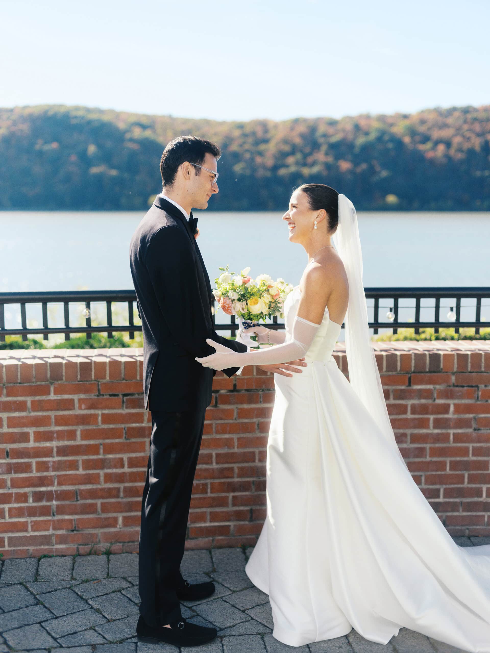 Elizabeth and Matt facing each other and holding hands at The Grandview terrace with Hudson River in the background — film wedding photography