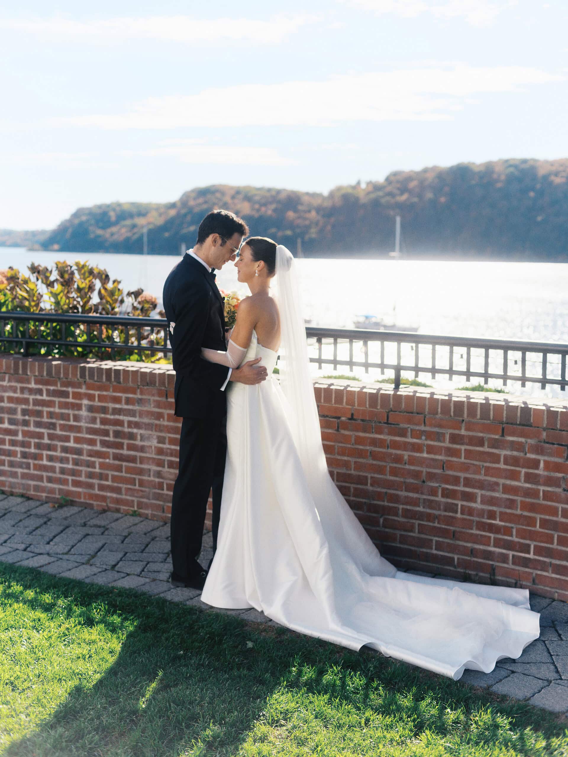 Elizabeth and Matt touching foreheads at The Grandview terrace wall with Hudson River behind them — intimate film wedding portrait
